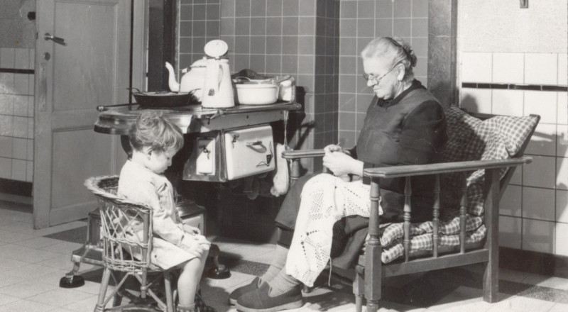 Oma en kleinkind zitten gezellig aan de Leuvense stoof, jaren ‘1950. Collectie KADOC-KU Leuven, Beeldarchief Boerenbond