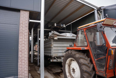 Mest van mooving floor stal wordt met transportband afgevoerd